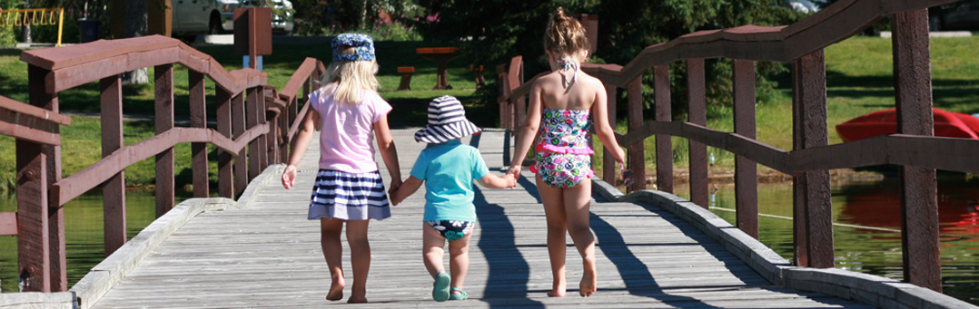 Three girls holding hands on the dock